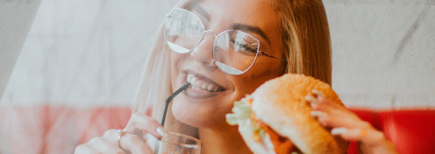 mujer sonriendo con hamburguesa